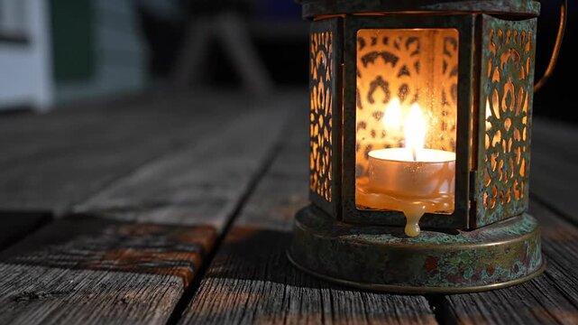 Vintage tealight lantern with intricate patterns and warm glowing candle, casting shadows on rustic wooden planks, creating a cozy atmosphere, perfect for decoration or ambiance