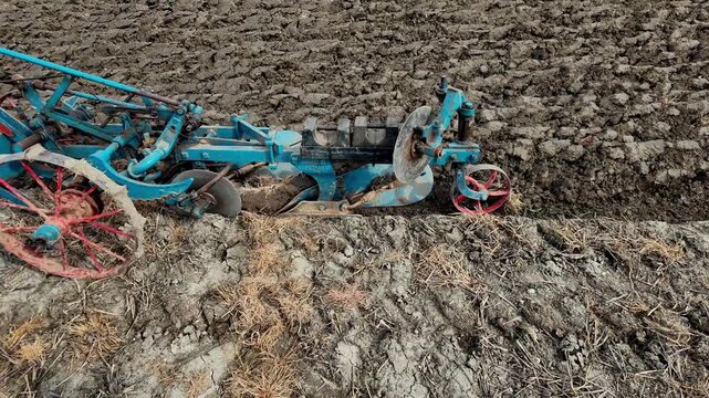 Close up of a plough ploughing a furrow and turning the soil