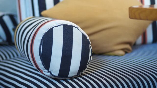 Close-up cinematic footage of stylish modern interior design featuring striped nautical patterns on cushions and sofa