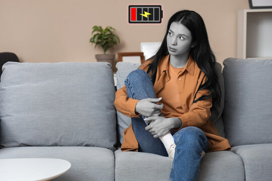 Portrait of worried young woman sitting on sofa