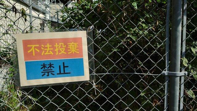 金網に掲示された不法投棄禁止の案内看板