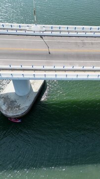 Vertical aerial drone shot along bridge in Koh Lanta Thailand with moving cars connecting islands tropical landscape 4K
