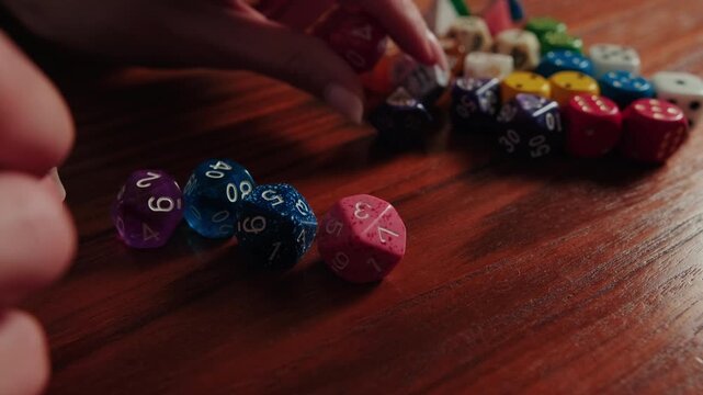 Hand Picking Up Colorful Polyhedral Dice For Tabletop Gaming