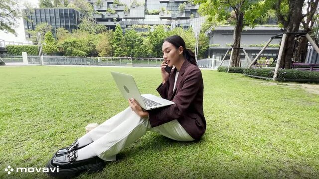 Girl enjoy listening music and reading a book and play laptop on the grass field of the park in the morning (greenery tone),Woman using tablet in park on a sunny day