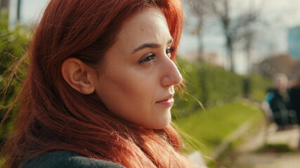 Profile Portrait of a Woman with Red Hair Outdoors © Andrii Nekrasov
