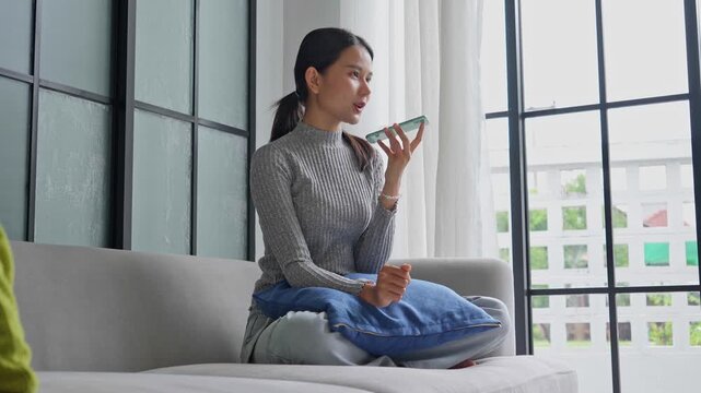 Woman talking with friend by using speaker phone