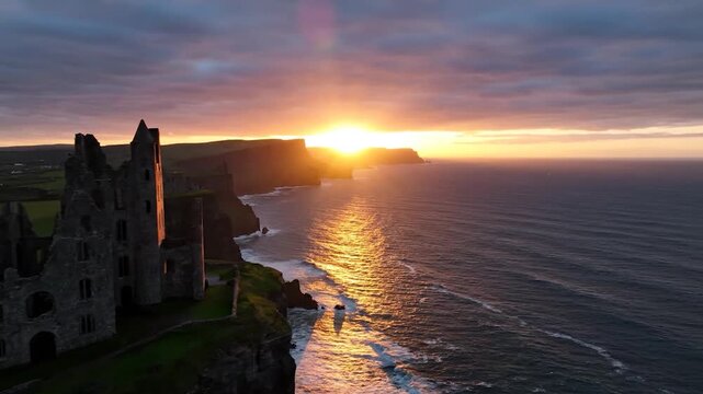 Ancient stone ruins stand on a cliff overlooking the ocean at sunset