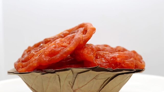 Closeup of Jalebi or Jilapi Heap Rotating in White Background with Copy Space, Also Known as Zalabia or Mushabak