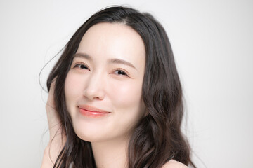 Naklejka premium 黒髪のパーマのロングヘア、ヘアケア美容ビューティー、カメラ目線の美しいアジア人(日本人)女性イメージ トリートメントや髪の毛のお手入れなどクローズアップ