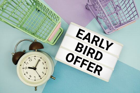 Early Bird Offer text in lightbox with trolley shopping cart and alarm clock flat lay on multicolor pastel background