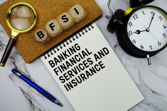 BFSI Banking Financial Services and Insurance text written on notepad with magnifying glass and alarm clock on marble background