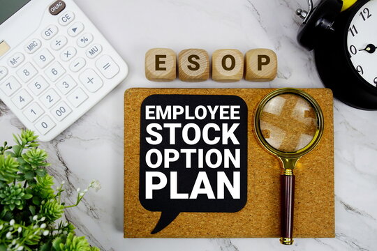 ESOP Employee Stock Option Plan text with calculator, magnifying glass and alarm clock on marble background