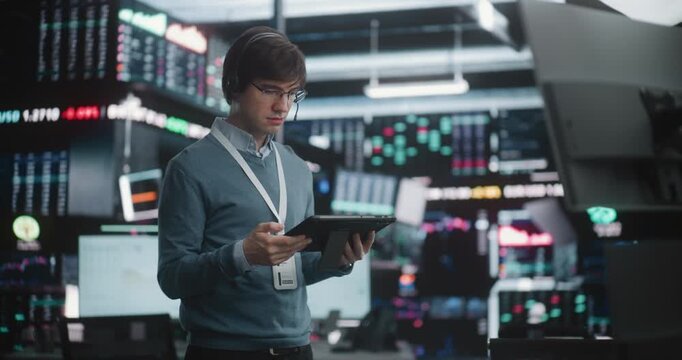 Man in Glasses Holds Digital Tablet, Looking Up Large Data Displays With of Calm Authority. Modern Financial Expert Tech Savvy, Determined, Ready Make Executive Decisions in Volatile Global Economy.