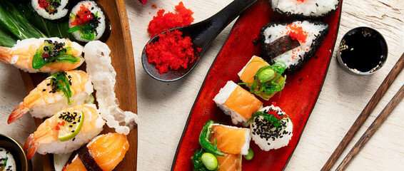 A table with Asian food, sushi, rolls, desserts. © bit24