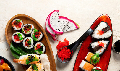 A table with Asian food, sushi, rolls, desserts. © bit24