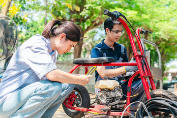 Obraz premium Female Startup Founder and Engineer Test Minibike Prototype at Small Business Workshop