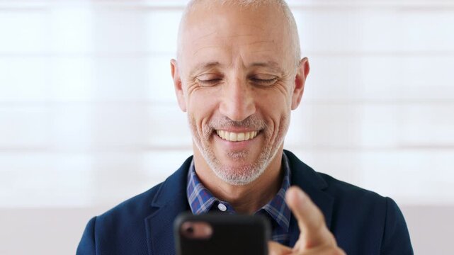 Business, funny and phone with happy man on in office for corporate development or management. App, laughing and scrolling with excited manager on wall background at work for mobile communication