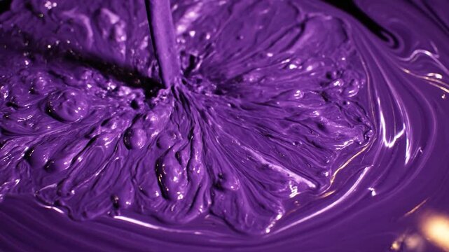 Viscous liquid creating abstract patterns as it flows into a pool