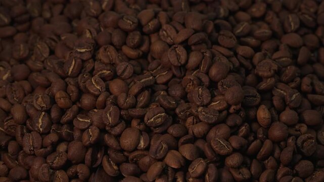 Slow motion shot of a spoon pushing coffee beans