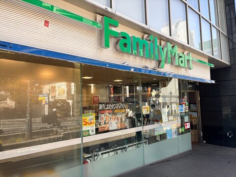 FamilyMart convenience store front with its iconic green and blue logo sign on an urban street in the popular Shibuya district - Tokyo, Japan, March 14, 2026