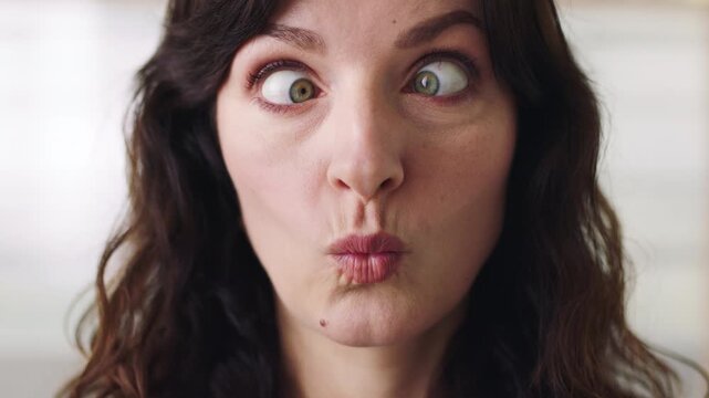 Funny face, pout and squint with silly woman in studio for comedy, goofy expression or humor. Comic, crazy and joke with playful person having fun for ,character, childish behavior or personality