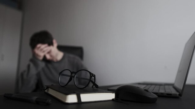 Work anxiety and overwhelm at desk in home office, man covering face with hand, economic uncertainty and job stress lifestyle