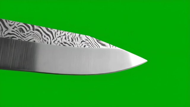 Close-up of a Damascus steel knife blade on a green screen background.