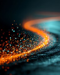 Fototapeta premium Glowing orange particles swirl in a curved path on a dark textured background with blue lights.