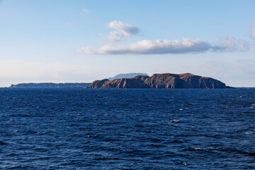 Fototapeta premium 式根島の野伏港、沖に神津島が見える。 新島港に接岸したところ。 東海汽船東京湾～伊豆諸島,太平洋航路のさるびあ船上- 2025 東京の竹芝桟橋を出港して、伊豆諸島の島々を巡るフェリー船、さるびあ丸に乗った。 伊豆大島から新島、式根島を経由して神津島まで到達する。 