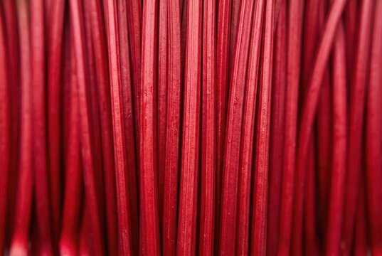 Vivid red textile strands arranged in parallel showcasing an intricate pattern emphasizing color saturation and texture for design enthusiasts and artistic expression