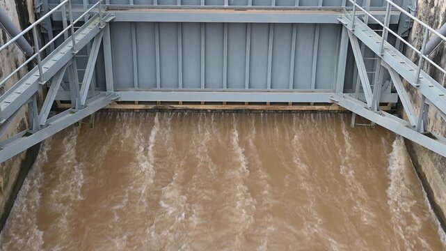 Spillway of Chiang Rai dam open for release water. Spillway, passage for surplus water over or around a dam when the reservoir itself is full.
