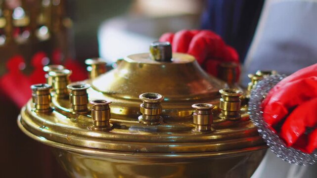 Humble obedience,cleaning brass church candelabra for Easter in an Orthodox cathedral