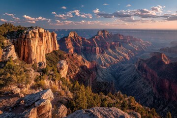 Naklejka premium Breathtaking sunset over the Grand Canyon illuminating vibrant rock formations and expansive valleys with dramatic clouds in the sky, showcasing natural beauty and geological features