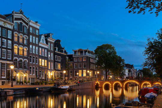 Amsterdam canal bridge illuminated in the evening