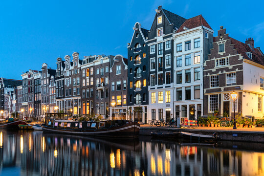 Amsterdam row houses and canal boats in the evening