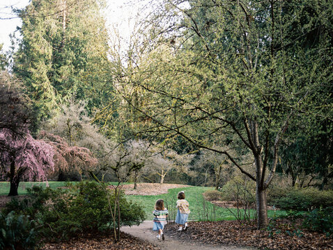 Twin little girls running through Washington Park Arboretum