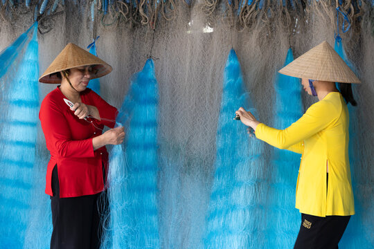 Women repairing fishing nets in Vietnam