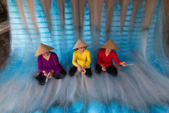 Woman repairing fishing nets in Vietnam