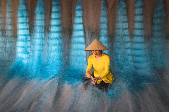 Woman repairing fishing nets in Vietnam