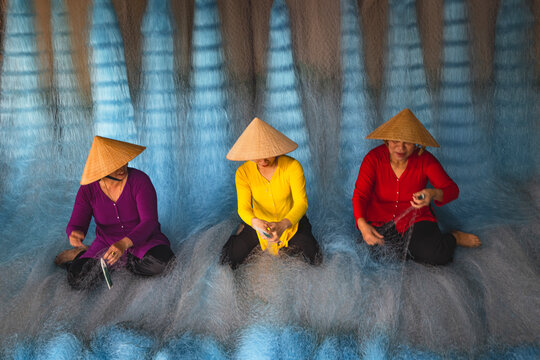 Woman repairing fishing nets in Vietnam