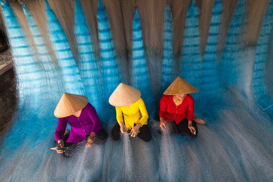 Woman repairing fishing nets in Vietnam