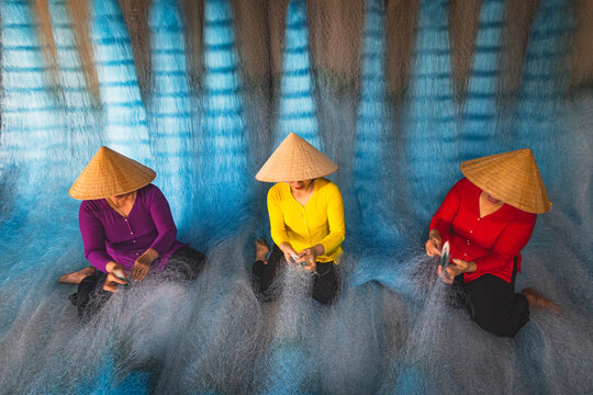 Women repairing fishing nets in Vietnam