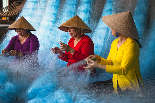Women repairing fishing nets in Vietnam