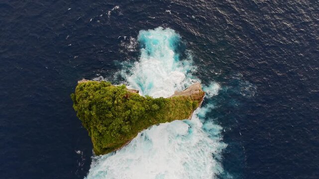 Top down drone view of ocean waves flowing through rock formation, abstract blue water texture with powerful surf, Bali, Indonesia.