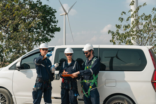 Wind turbine team clean energy worker near van focus on safety sustainability wind energy service outdoor