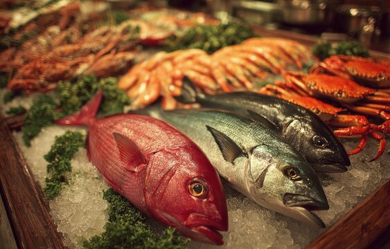 Fresh seafood display featuring red snapper, bluefish, and blackfish on ice with shrimp and crabs, garnished with green parsley in a market setting