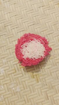 String hopper or idiyappam preparation pink and white on woven bamboo mat traditional sri lankan and south indian food culture