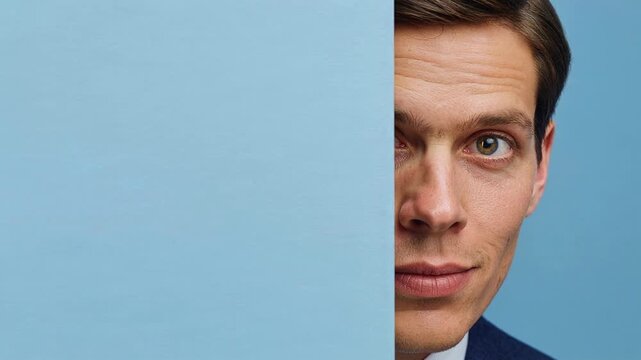 Portrait of man partially hidden behind panel capturing curiosity identity and modern composition with clean background and focused gaze in minimal studio setting