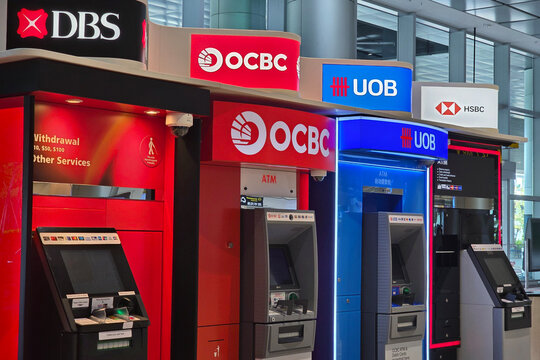 Changi, Singapore - Jan 21, 2026: A line of automated teller machines ATM including DBS, OCBC, UOB, and HSBC located in Terminal 2 of Singapore Changi Airport.