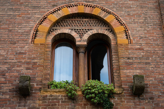 Historic medieval bifora window with a central column and arched brickwork on a facade in Padova, Italy 02.01.2026